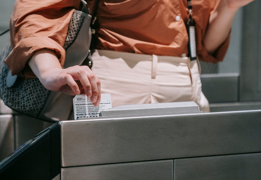 Visitor passing through an entrance turnstile with a badge